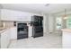 Kitchen with black appliances and white cabinets at 2467 E Del Webb Blvd, Sun City Center, FL 33573