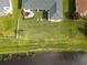 Aerial view showcases home's backyard with a lake view, fire pit, patio, screened in patio, and lush lawn at 2603 River Woods Dr, Parrish, FL 34219