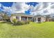 Spacious backyard with a well-maintained lawn, screened lanai, a fire pit, and tropical plants for outdoor enjoyment at 2603 River Woods Dr, Parrish, FL 34219