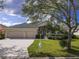 Attractive home with a well-manicured lawn and a two-car garage, nestled among mature trees in a quiet neighborhood at 2603 River Woods Dr, Parrish, FL 34219