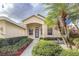 Inviting single-Gathering home with a charming front entrance, a lush landscaped garden, and mature palm trees at 2603 River Woods Dr, Parrish, FL 34219