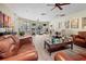 Bright living room with wood floors, ceiling fan, and comfortable leather seating in a shared community space at 2603 River Woods Dr, Parrish, FL 34219