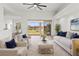 Bright living room featuring modern furniture, neutral decor, a ceiling fan, and sliding glass doors overlooking the water at 2603 River Woods Dr, Parrish, FL 34219