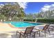 Beautiful community pool with lounge chairs and well maintained fence and trees for a relaxing afternoon in the sun at 2603 River Woods Dr, Parrish, FL 34219