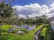 Scenic view of a tranquil lake with lush greenery and a walking path at 2603 River Woods Dr, Parrish, FL 34219