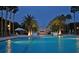 Stunning lighted pool at night with palm trees at 415 L Ambiance Dr # C703, Longboat Key, FL 34228