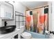 Clean bathroom with a clawfoot tub, black sink, and patterned shower curtain at 4403 Pike Ave, Sarasota, FL 34233