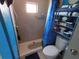 Small bathroom with shower, toilet, and shelving unit at 5021 Pebble Beach Ave, Sarasota, FL 34234