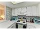 Kitchen with white cabinets, tile backsplash, and teal appliances at 6309 Manatee W Ave # 6309, Bradenton, FL 34209