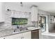 Kitchen with double sink, granite countertops and view of backyard pool at 15277 Mille Fiore Blvd, Port Charlotte, FL 33953