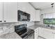 Kitchen detail with black appliances and granite countertops at 15277 Mille Fiore Blvd, Port Charlotte, FL 33953