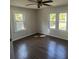 Bright bedroom featuring dark wood floors, vertical wood paneling, and two windows at 1936 E 30Th Ave, Bradenton, FL 34208