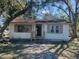 Charming one-story home with neutral siding, brown trim, and mature trees in front yard at 1936 E 30Th Ave, Bradenton, FL 34208