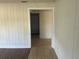 Hallway featuring dark wood floors and vertical wood paneling with doorway to tile flooring at 1936 E 30Th Ave, Bradenton, FL 34208