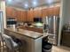 Well-lit kitchen boasts wood cabinets, granite countertops, stainless appliances, and a breakfast bar at 2271 50Th Street E Cir, Palmetto, FL 34221