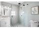 Modern bathroom with a glass shower, white vanity, and scalloped mirror at 243 S Harbor Dr, Holmes Beach, FL 34217
