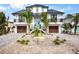Two-story home with a metal roof, two-car garage, and landscaped front yard at 243 S Harbor Dr, Holmes Beach, FL 34217
