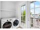 Laundry room with washer, dryer, and access to balcony at 243 S Harbor Dr, Holmes Beach, FL 34217