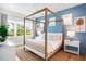 Spacious main bedroom with a four-poster bed and blue accent wall at 243 S Harbor Dr, Holmes Beach, FL 34217