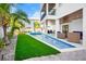 Modern rectangular pool with artificial turf and patio furniture at 243 S Harbor Dr, Holmes Beach, FL 34217