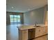 Open concept kitchen with island, stainless steel appliances, and views to living room at 24732 Buckingham Way, Port Charlotte, FL 33980