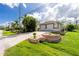 View of a home's side with a large driveway and well maintained landscaping at 2629 Rolling Rd, North Port, FL 34288