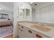 Bathroom featuring a large mirror, and white cabinets with unique wooden pulls at 3375 Sandleheath # 34, Sarasota, FL 34235