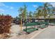 Parking area with a row of golf carts, benches, and landscaping on a sunny day at 3375 Sandleheath # 34, Sarasota, FL 34235