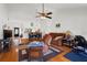 Comfortable living room with wood floors, ceiling fan, brown sofa, and adjacent dining area at 3375 Sandleheath # 34, Sarasota, FL 34235