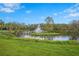 Scenic view of a pond with a fountain surrounded by lush greenery and a clear blue sky at 3375 Sandleheath # 34, Sarasota, FL 34235