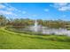 Serene pond view featuring a central fountain, framed by lush green landscape, showcasing a peaceful community ambiance at 3375 Sandleheath # 34, Sarasota, FL 34235