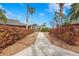 Landscaped walking path leading to a building with palm trees and a pergola on the property at 3375 Sandleheath # 34, Sarasota, FL 34235
