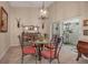 Elegant dining room with a glass-top table and four coral chairs, access to patio at 3410 Avenida Madera # B, Bradenton, FL 34210
