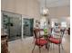 Sunlit dining area with glass-top table and four coral chairs, opens to living room at 3410 Avenida Madera # B, Bradenton, FL 34210
