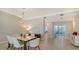 Modern dining room featuring a glass-top table and six white chairs at 535 Sanctuary Dr # C807, Longboat Key, FL 34228