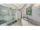 Bathroom with walk-in shower, double vanity, and marble tile at 535 Sanctuary Dr # C807, Longboat Key, FL 34228