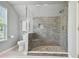 Walk-in shower with gray stone tile and built-in seat at 6008 Hammock Woods Dr, Odessa, FL 33556