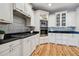 Modern kitchen featuring white cabinets, stainless steel appliances, and granite countertops at 6008 Hammock Woods Dr, Odessa, FL 33556