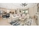 Open concept living space with a white sofa, large windows, and views of the kitchen at 6249 Mesa Gln, Bradenton, FL 34203
