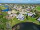 An aerial view shows the home with a screened-in pool, situated on a lot with pond access in a residential neighborhood at 6637 Pleasant Hill Rd, Bradenton, FL 34203