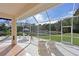 Relaxing screened-in patio showcases comfortable lounge chairs and peaceful views of the backyard and pond at 6637 Pleasant Hill Rd, Bradenton, FL 34203