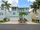 Two-story home with light teal exterior and palm trees at 741 Shakett Creek Dr, Nokomis, FL 34275