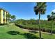 Waterfront view with lush landscaping and palm trees at 8779 Midnight Pass Rd # 206H, Sarasota, FL 34242