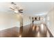 Open living room with dark hardwood floors, a kitchen, and a staircase at 9016 White Sage Loop, Lakewood Ranch, FL 34202