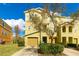 Three-story townhome with tan siding and a two-car garage at 9016 White Sage Loop, Lakewood Ranch, FL 34202