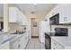Kitchen with white cabinets and black appliances at 980 Cooper St # 302, Venice, FL 34285