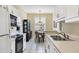 Kitchen with white cabinets, black appliances, and dining area at 980 Cooper St # 302, Venice, FL 34285