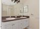 Bathroom with double sinks, white cabinets, and a large mirror at 10550 Old Grove Cir, Bradenton, FL 34212