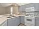 Gray cabinets, white appliances, and quartz countertops at 10550 Old Grove Cir, Bradenton, FL 34212