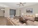 Living room with beige sofas, coffee table, and ceiling fan at 10550 Old Grove Cir, Bradenton, FL 34212